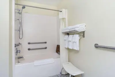 a bathroom with a shower and a toilet and towels at Baymont Inn & Suites by Wyndham Huber Heights Dayton Northeast in Huber Heights