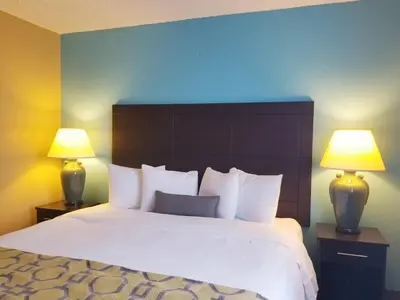 a bedroom with a large bed with two lamps at Baymont Inn & Suites by Wyndham Huber Heights Dayton Northeast in Huber Heights