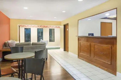 a waiting room with a counter and a table and chairs at Baymont Inn & Suites by Wyndham Huber Heights Dayton Northeast in Huber Heights