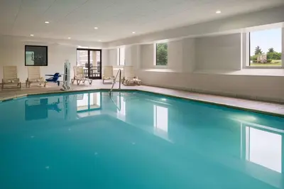 a swimming pool with blue water in a building at Baymont by Wyndham Georgetown Lexington North in Georgetown