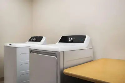 two washing machines sitting next to each other in a room at Baymont by Wyndham Georgetown Lexington North in Georgetown