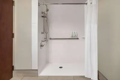 a bathroom with a shower with a white shower curtain at Baymont by Wyndham Georgetown Lexington North in Georgetown