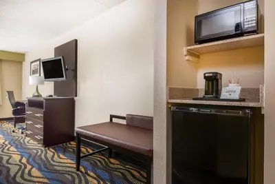 a hotel room with a chair and a television at Baymont by Wyndham Georgetown Lexington North in Georgetown