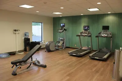 a gym with several treadmills and machines in a room at Holiday Inn Express Wilmington by IHG in Wilmington