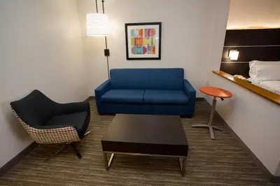 a living room with a blue couch and a chair at Holiday Inn Express Wilmington by IHG in Wilmington