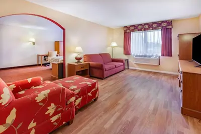 a living room with a couch a chair and a television at Baymont by Wyndham Perrysburg-Toledo in Perrysburg