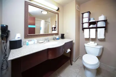 a bathroom with a sink and a toilet and a mirror at Hampton Inn & Suites Greensburg in Greensburg