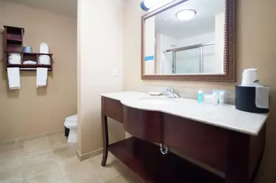 a bathroom with a sink and a mirror and a toilet at Hampton Inn & Suites Greensburg in Greensburg