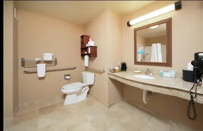 a bathroom with a toilet and a sink and a mirror at Hampton Inn & Suites Greensburg in Greensburg