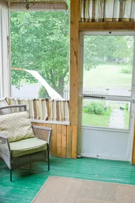 a screened in porch with a chair and a window at Aunt Jane's Guest House in Put-in-Bay