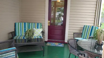 a porch with two chairs and a purple door at Aunt Jane's Guest House in Put-in-Bay