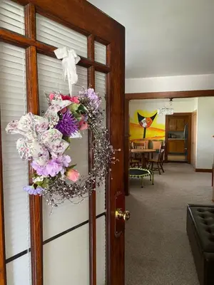 a door with a wreath on it with a dining room at Picasso's Condo in Van Wert