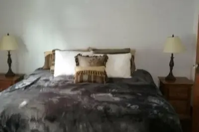 a bedroom with a large bed with two lamps at Picasso's Condo in Van Wert