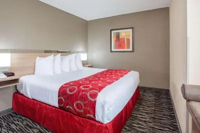 a hotel room with a large bed with a red blanket at Microtel Inn & Suites by Wyndham Charleston in Charleston