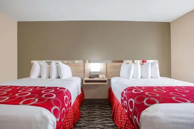 a hotel room with two beds with red and white covers at Microtel Inn & Suites by Wyndham Charleston in Charleston
