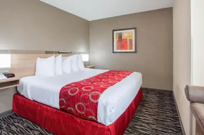 a hotel room with a large bed with a red blanket at Microtel Inn & Suites by Wyndham Charleston in Charleston