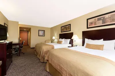 a hotel room with two beds and a television at Wingate by Wyndham Dayton - Fairborn in Fairborn