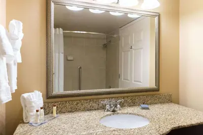 a bathroom with a sink and a large mirror at Wingate by Wyndham Dayton - Fairborn in Fairborn