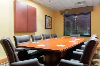 a conference room with a large wooden table and chairs at Wingate by Wyndham Dayton - Fairborn in Fairborn