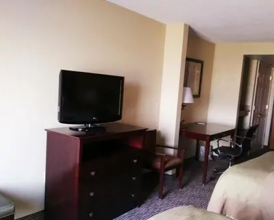 a hotel room with a television on a dresser with a bed at Wingate by Wyndham Dayton - Fairborn in Fairborn