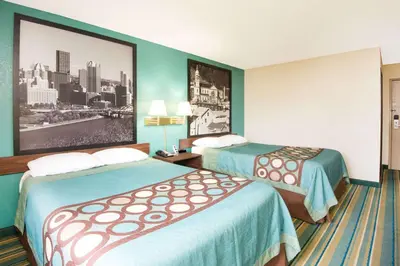 a hotel room with two beds and a picture on the wall at Super 8 by Wyndham Pittsburgh PA Airport-University Area in Moon Township