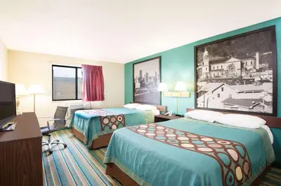 a hotel room with two beds and a tv at Super 8 by Wyndham Pittsburgh PA Airport-University Area in Moon Township