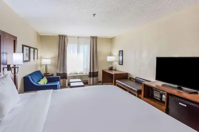 a hotel room with a large bed and a flat screen tv at Comfort Inn Charleston South in Charleston