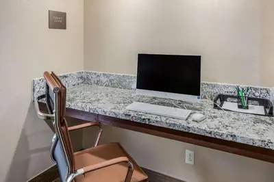 a desk with a computer and a keyboard and mouse at Comfort Inn Charleston South in Charleston