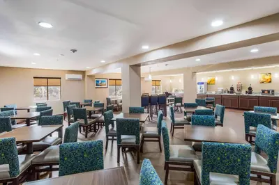 a restaurant with tables and chairs and a bar at Comfort Inn Charleston South in Charleston
