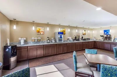 a restaurant with a bar with blue chairs at Comfort Inn Charleston South in Charleston
