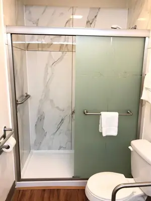 a bathroom with a shower with a glass door at Motel 6-Parkersburg, WV in Parkersburg