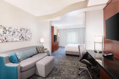 a hotel room with a couch and a bed at Courtyard by Marriott Pittsburgh Washington Meadow Lands in Washington