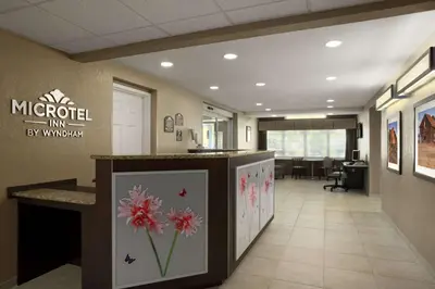 an office lobby with a reception counter with flowers on it at Microtel Inn & Suites By Wyndham Mineral Wells/Parkersburg in Mineralwells