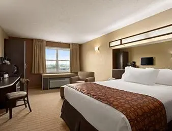 a hotel room with a large bed and a desk at Microtel Inn & Suites By Wyndham Mineral Wells/Parkersburg in Mineralwells