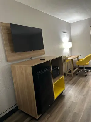 a room with a flat screen tv on a wall at Days Inn by Wyndham Huntington in Pea Ridge