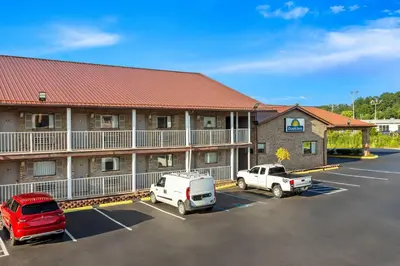 a hotel with cars parked in a parking lot at Days Inn by Wyndham Huntington in Pea Ridge