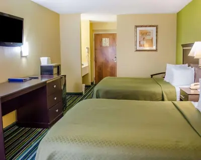 a hotel room with two beds and a desk at Quality Inn & Suites Medina - Akron West in Medina