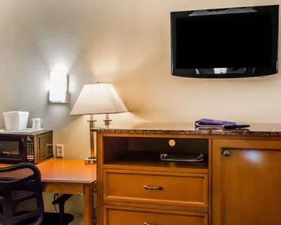 a hotel room with a desk and a tv on the wall at Quality Inn & Suites Medina - Akron West in Medina