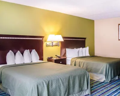 two beds in a hotel room with yellow walls at Quality Inn & Suites Medina - Akron West in Medina