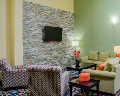 a living room with a tv on a brick wall at Quality Inn & Suites Medina - Akron West in Medina