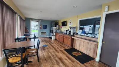 a restaurant with a bar and a table and chairs at Super 8 by Wyndham Centerville-Richmond in Centerville