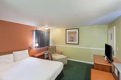 a hotel room with a bed and a television at Rodeway Inn Wauseon in Wauseon