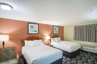 a hotel room with two beds and two lamps at Rodeway Inn Wauseon in Wauseon