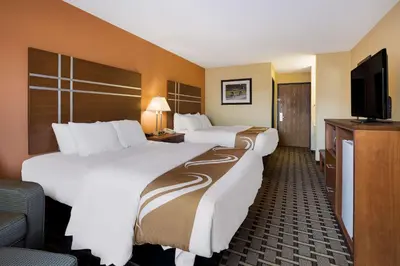 a hotel room with two beds and a flat screen tv at Quality Inn Ashland East in Ashland