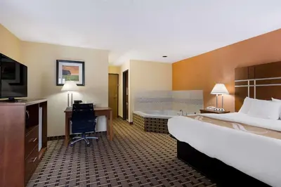 a hotel room with a bed and a bath tub at Quality Inn Ashland East in Ashland