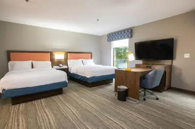 a hotel room with two beds and a flat screen tv at Hampton Inn & Suites Wilder in Wilder