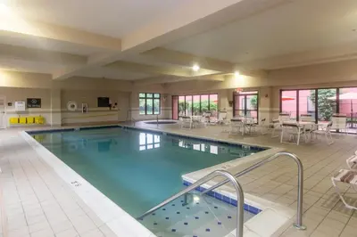 a large swimming pool in a hotel with tables and chairs at Hampton Inn & Suites Wilder in Wilder
