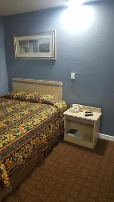 a hotel room with a bed and a phone on a table at Travel Inn in Sharonville