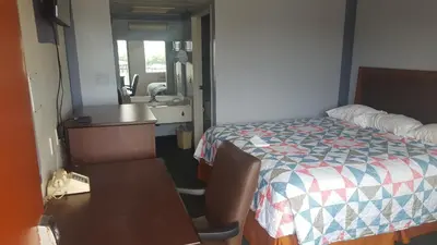 a room with a bed and a desk and a sink at Travel Inn in Sharonville