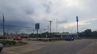 a parking lot with a gas station and a car at Travel Inn in Sharonville